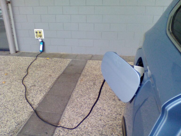 An electric vehicle plugged into a wall to charge