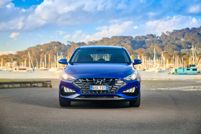 A blue Hyundai i30 with the boats in the background
