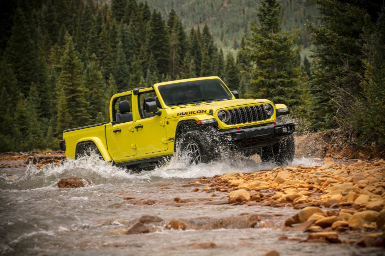 Latest model Jeep Gladiator in yellow crossing a creek